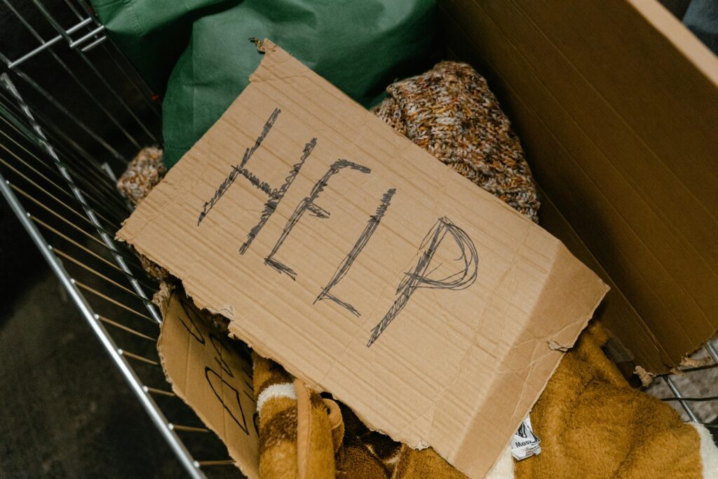 Picture of a sign that reads "Help" on top of donated items